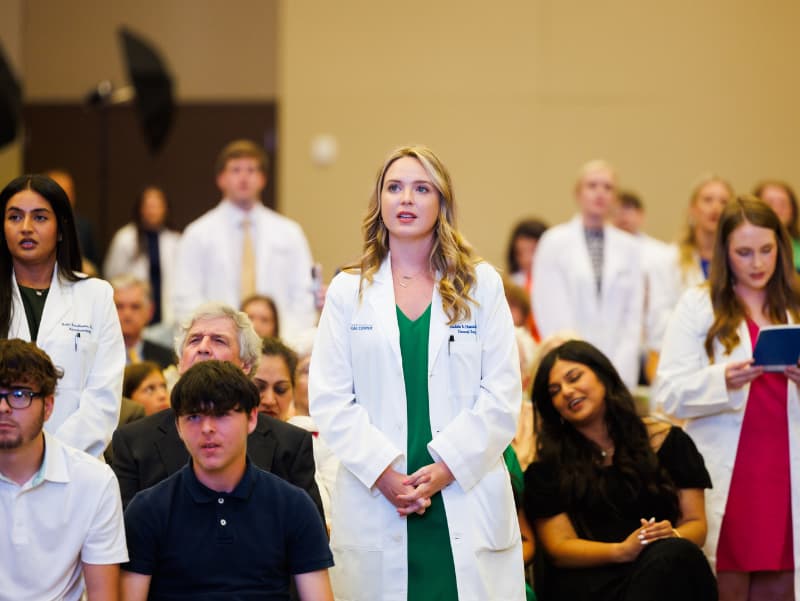 Newly-coated fourth year students recite the Hippocratic Oath.